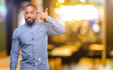 Poster - African american man with beard unhappy making suicide gesture, tired of everything. Shoots with hand imitating gun, upset at night