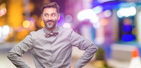 Canvas Print - Middle age man, with beard and bow tie confident and happy with a big natural smile laughing at night club