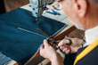 cropped image of senior tailor cutting cloth at sewing workshop