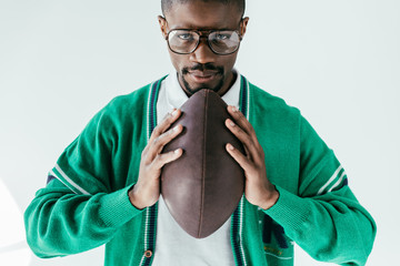 Wall Mural - handsome african american man holding rugby ball, isolated on white