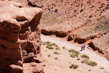 Two tourists go to the gorge Charyn canyon in Kazakhstan