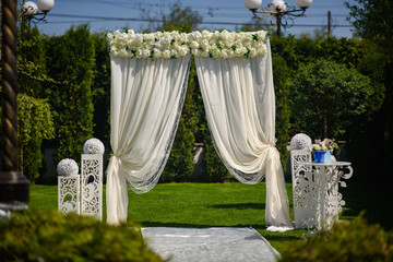 Arch for the wedding ceremony, decorated with cloth and flowers