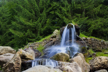 Beautiful artificial waterfalls, in the background are green pine trees. (izvorul minunilor) Romania, Stana de Vale