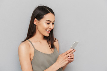 Canvas Print - Portrait of a smiling asian woman using mobile phone