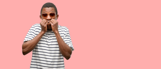 Wall Mural - African black man wearing sunglasses terrified and nervous expressing anxiety and panic gesture, overwhelmed