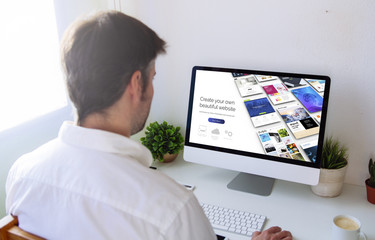 Wall Mural - man browsing website builder on computer