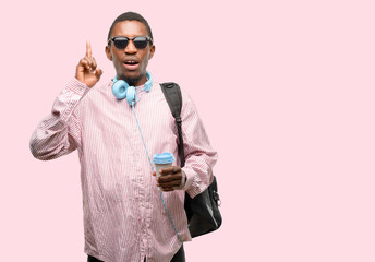 Poster - African black man student happy and surprised cheering expressing wow gesture pointing up