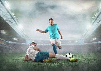 Wall Mural - Soccer player on a football field in dynamic action at summer day