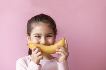 Wall Mural - Little girl with yellow banana like smile