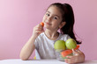 © kaganskaya115 - A cute little girl eating fresh vegetables. A portrait on а pastel background. Healthy teeth.