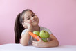 © kaganskaya115 - A cute little girl eating fresh vegetables. A portrait on ? pastel background. Healthy teeth.