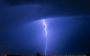 Severely lightning thundering down the center town. At the night.