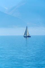  A small sailing yacht on the Lake Geneva and the Alps, Switzerland