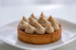 tartlet with nuts and caramel on white plate