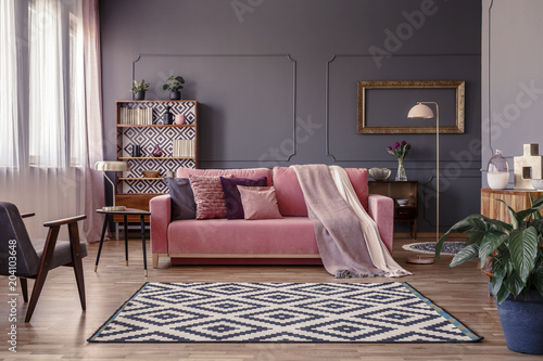 Fotografía Pink sofa with two blankets and cushions standing in sitting room interior with