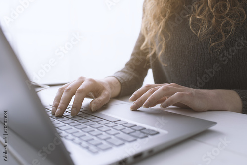 Fotografía Woman sitting at desk and connecting with her laptop
