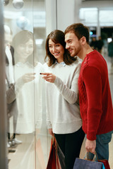 Wall Mural - Shopping Mall. Man And Woman Looking Through Store Window