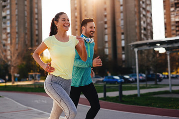 young attractive couple running outside on sunny day