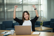© reewungjunerr - Beautiful asian businesswoman working at the office  in the evening,Thailand worker happy after looking laptop,Success from work
