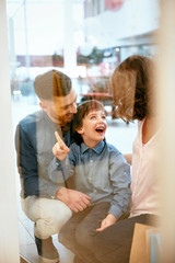 Wall Mural - Family In Shopping Mall. People Looking Through Window