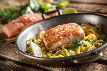 Pieces of roasted salmon with pasta tagliatelle lemon and basil