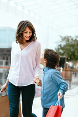 Wall Mural - Shopping. Young Mother And Kid With Bags In Mall