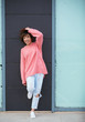 © ManuPadilla - Portrait of a happy young woman wearing a piercing on her nose with a pink sweater on black background. lifestyle concept