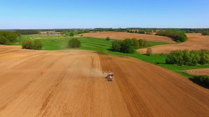 Wall Mural - Aerial view of a modern tractor working on the dry agricultural field - tractor plowing and sowing in the agricultural field the summer