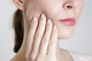 Studio shot of young woman with tooth pain, close up 