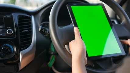 4K Hands of woman using using tablet with green screen monitor at interior of SUV car for mobile application technology and transport concept