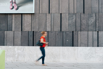  Woman moving against modern architecture concrete wall