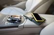 © Andrii - A telephone and purse lie on an elbow-rest in the salon of car