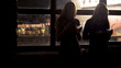 © motortion - Silhouettes of young women checking messages on smartphones at dawn after party