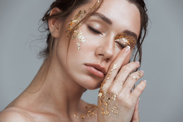 brunette woman with soft healthy skin and golden makeup