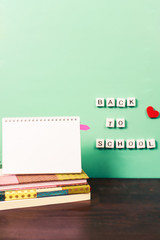 Wall Mural - Back to school supplies pastel workspace with trendy items wooden letters on a board and blank notepad