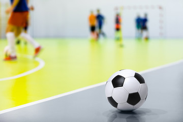 Indoor Soccer Futsal Ball. Indoor Soccer Match in the Background. Indoor Soccer Sports Hall. Sports Background. Youth Futsal League. Classic Soccer Ball.