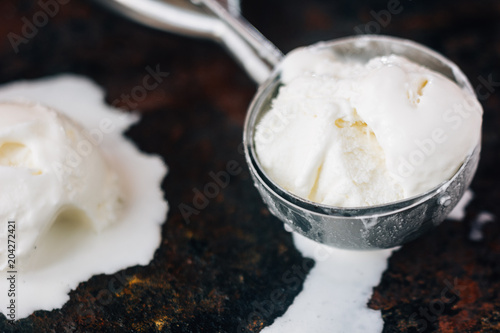 Fotografía Close view of ice cream scoop with white ice cream starting to melt in it