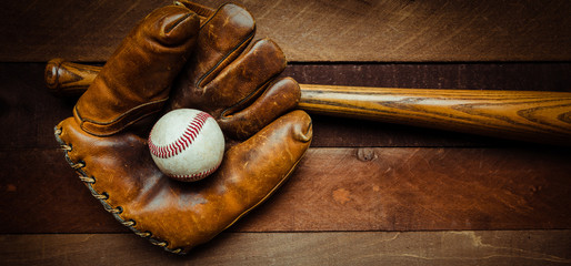 Wall Mural - A group of vintage baseball equipment, bats, gloves, baseballs on wooden background