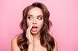 Close up portrait of cute charming gossip naked girl with wavy hair and trendy, modern make up holding hand near mouth and telling secret, looking at side with eyes, standing over pink background