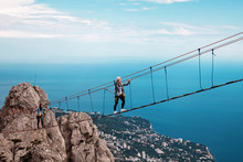 Young Woman Crossing The Chasm On The Rope Bridge. Ai-Petri, Crimea