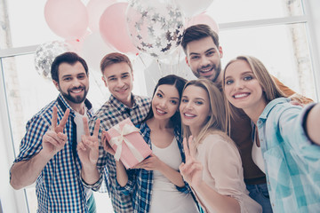 Wall Mural - Creative, stylish, attractive, cheerful business people having air balloons cases in package with bow shooting self portrait on front camera showing peace symbol two fingers celebrating event