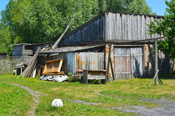 The household garbage lies about the old wooden shed. Polessk, Kaliningrad region