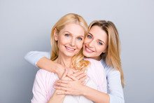 Portrait Of Stylish Cute Attractive Charming Mother And Daughter, Family With One Single Parent, Warm Hugs, Looking At Camera Isolated On Grey Background