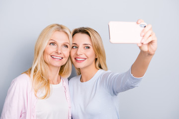 Sticker - Cheerful cute charming blogger shooting self portrait on front camera with attractive pretty mom using smart phone enjoying time together, selfie mania, addicted people, isolated on grey background