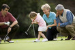 © Erickson Stock - Family teaching young daughter to play golf