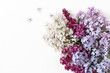 Styled stock photo. Spring feminine scene, floral composition. Bunch of beautiful blossoming purple and white lilac branches. White table background. Flat lay, top view.