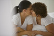 © Erickson Stock - Two women kissing on a bed.
