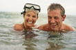 © Erickson Stock - Portrait of a happy mid adult couple swimming in the ocean together.