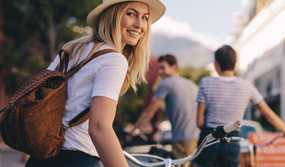 Woman with friends on city tour with bike