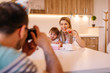 © Nebojsa - Young father is making photo of his daughter and her mother with birthday cake and gift box